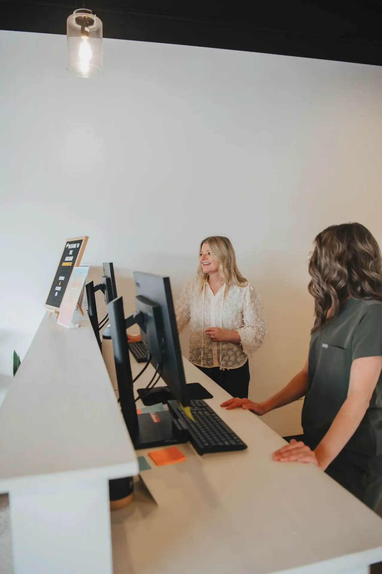 Welcoming team greeting a practice member at the front desk
